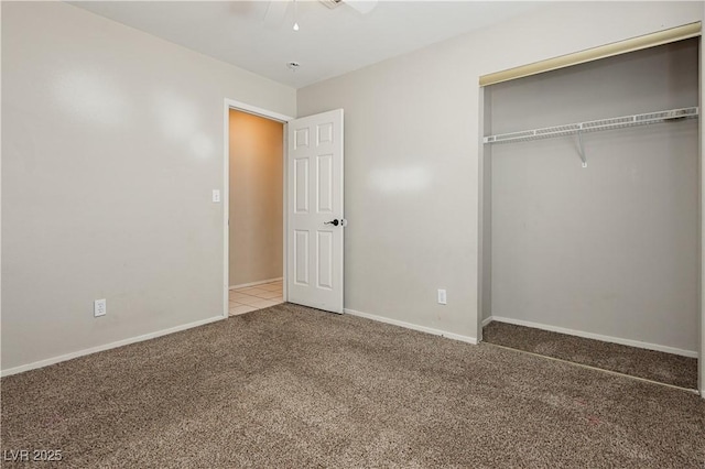 unfurnished bedroom featuring carpet floors, baseboards, a closet, and ceiling fan