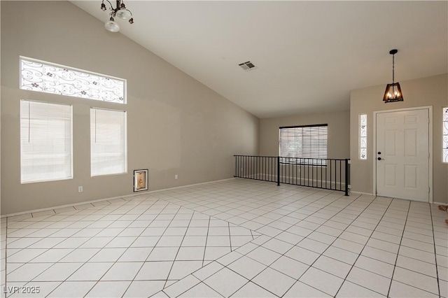 foyer entrance featuring light tile patterned flooring, a notable chandelier, high vaulted ceiling, baseboards, and visible vents