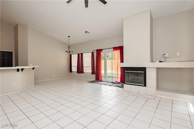unfurnished living room with visible vents, a tiled fireplace, ceiling fan with notable chandelier, lofted ceiling, and light tile patterned flooring