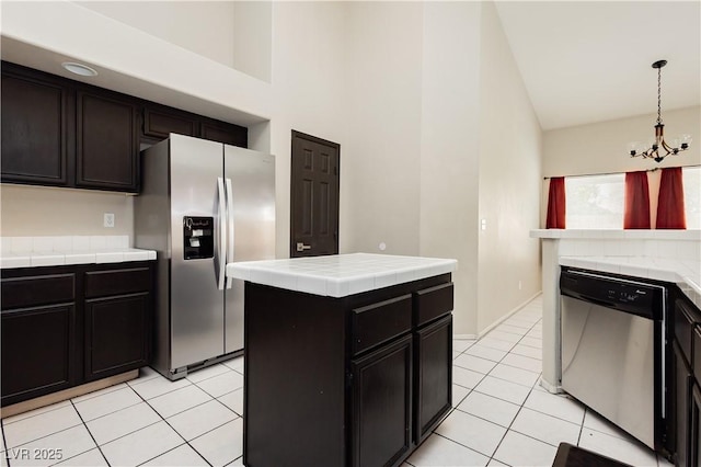 kitchen with tile counters, a notable chandelier, appliances with stainless steel finishes, and light tile patterned flooring