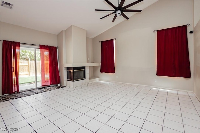 unfurnished living room featuring ceiling fan, light tile patterned floors, lofted ceiling, a tile fireplace, and visible vents
