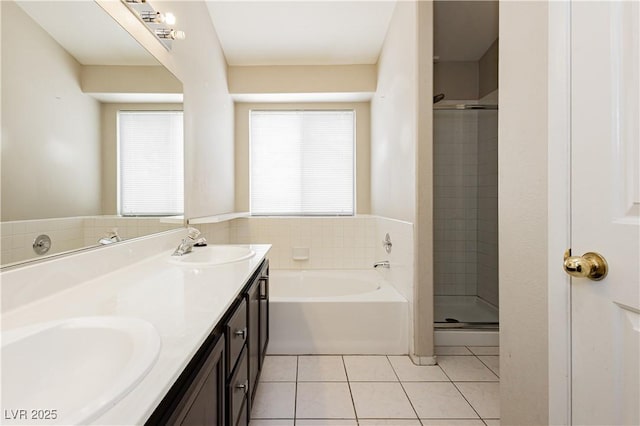 full bath with tile patterned flooring, a sink, a stall shower, and double vanity