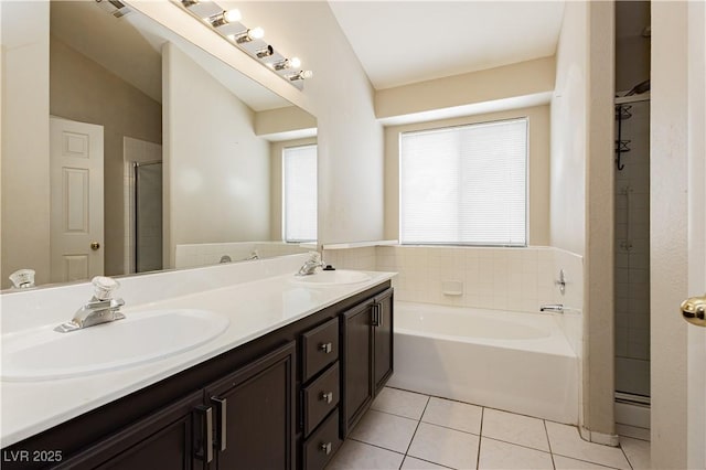 bathroom featuring a sink, tile patterned floors, a stall shower, and a healthy amount of sunlight