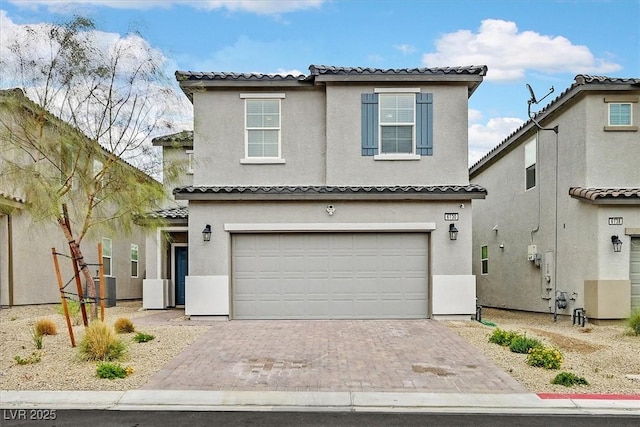 traditional home with an attached garage, a tile roof, stucco siding, and decorative driveway