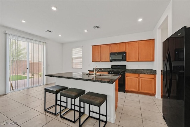 kitchen featuring brown cabinetry, visible vents, and black appliances