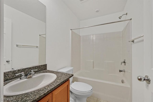 bathroom featuring tile patterned flooring, toilet, vanity, and bathing tub / shower combination