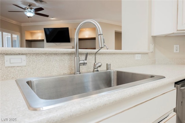 interior details with white cabinetry, light countertops, crown molding, and a sink