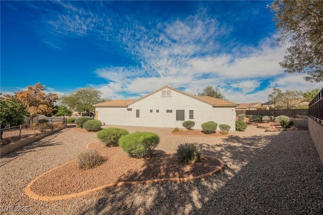 view of side of home featuring stucco siding and a fenced backyard