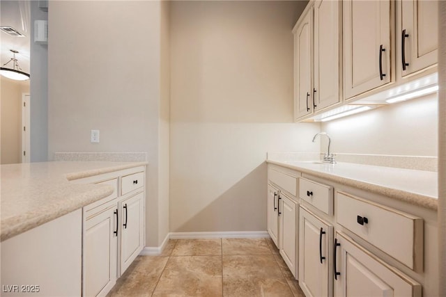 clothes washing area featuring a sink, baseboards, and visible vents