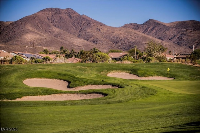 view of community featuring golf course view, a yard, and a mountain view