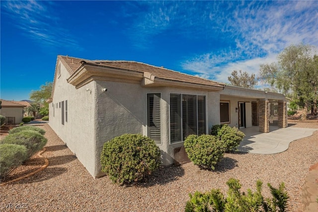 rear view of property with a patio and stucco siding