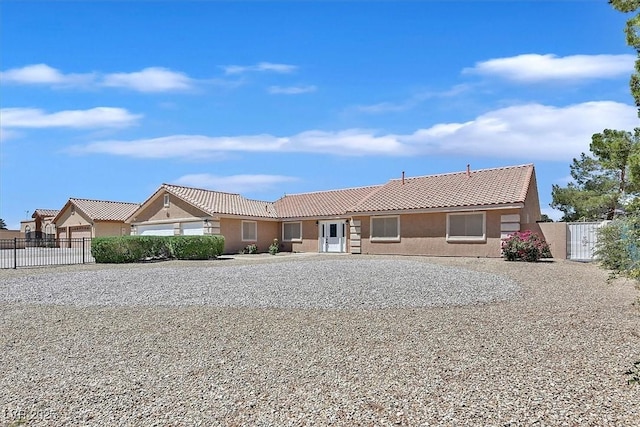 view of front of property with fence, stucco siding, and a tile roof