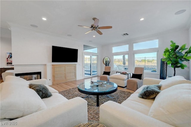 3091 Via Del Corso, Henderson, NV 89052 - living room with visible vents, a glass covered fireplace, wood finished floors, recessed lighting, and a ceiling fan