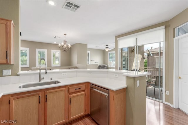 kitchen featuring stainless steel dishwasher, a sink, visible vents, and light wood-style flooring