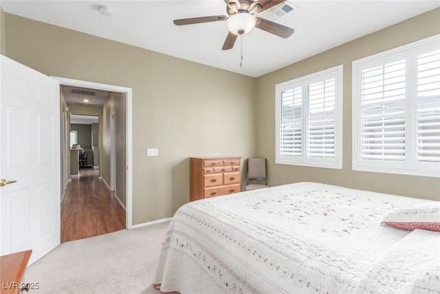 carpeted bedroom featuring baseboards, visible vents, and a ceiling fan