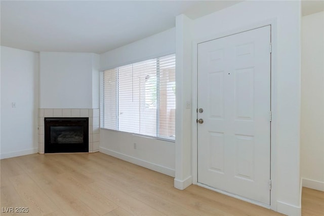 8450 Alta Dr Unit 136, Las Vegas, NV 89145 - foyer featuring baseboards, a tiled fireplace, and light wood-style floors
