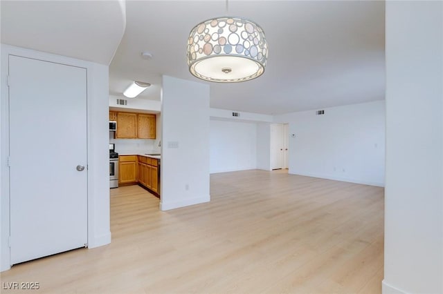 8450 Alta Dr Unit 136, Las Vegas, NV 89145 - unfurnished living room featuring visible vents, light wood-type flooring, and baseboards