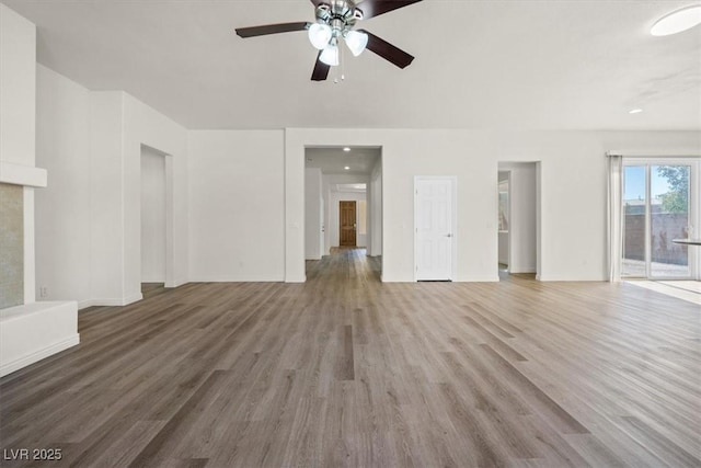 unfurnished living room with wood finished floors, a ceiling fan, and baseboards