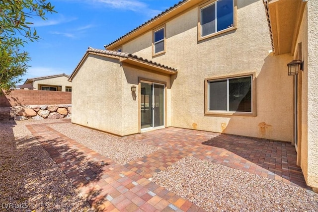 back of property with a patio, stucco siding, and fence
