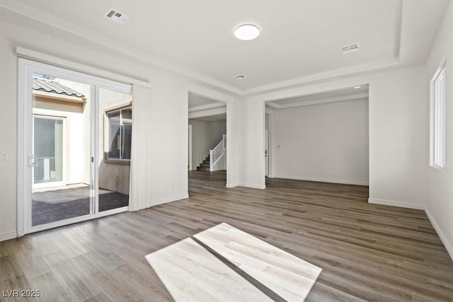 unfurnished bedroom with wood finished floors, visible vents, access to exterior, and baseboards