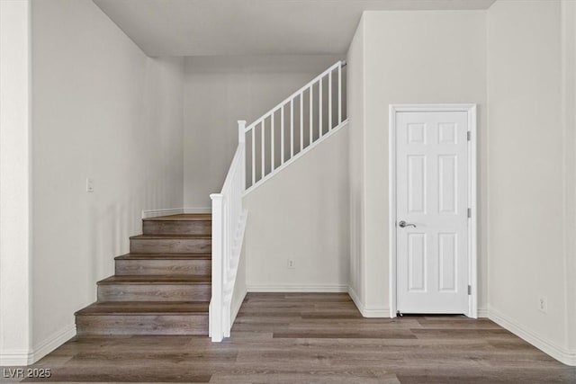 stairway featuring wood finished floors and baseboards