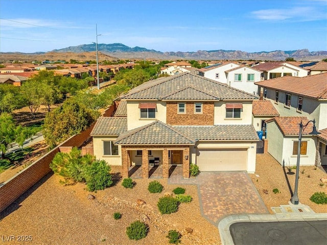 mediterranean / spanish house with a residential view, driveway, a tiled roof, and stucco siding