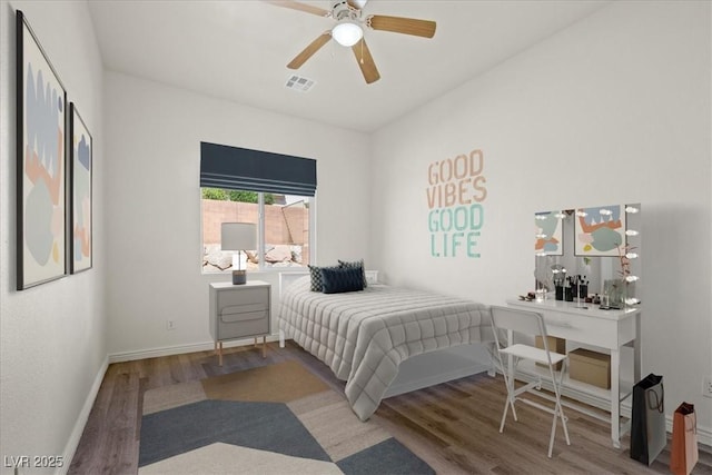 bedroom featuring baseboards, visible vents, wood finished floors, and ceiling fan