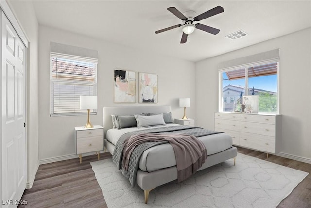 bedroom with visible vents, ceiling fan, wood finished floors, and baseboards