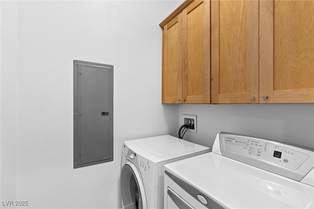 laundry room with washer and dryer, cabinet space, and electric panel