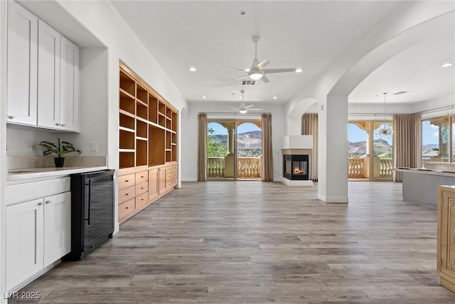 unfurnished living room with visible vents, beverage cooler, light wood-style floors, and recessed lighting