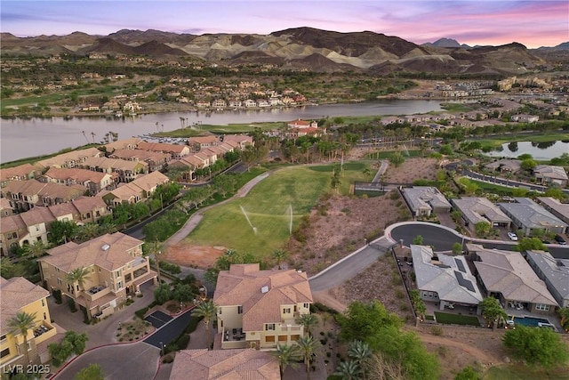 aerial view at dusk featuring a residential view and a water and mountain view