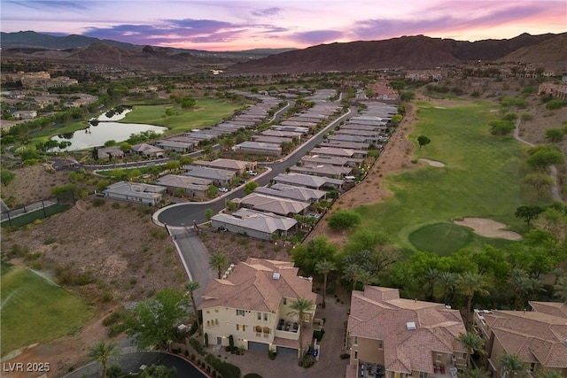 aerial view at dusk featuring a water and mountain view, a residential view, and view of golf course