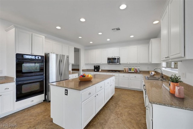 3217 Palladio Ave, North Las Vegas, NV 89031 - kitchen featuring stainless steel appliances, a kitchen island, white cabinets, recessed lighting, and dark stone counters