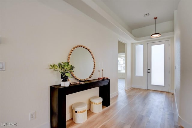 entrance foyer with baseboards, light wood-type flooring, and visible vents
