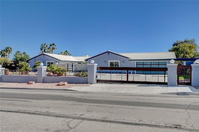 7575 Coley Ave, Las Vegas, NV 89117 - view of front facade with concrete driveway, a fenced front yard, a garage, a tile roof, and a gate