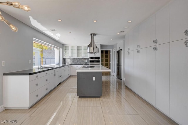 7575 Coley Ave, Las Vegas, NV 89117 - kitchen with white cabinetry, freestanding refrigerator, tasteful backsplash, a kitchen island with sink, and recessed lighting