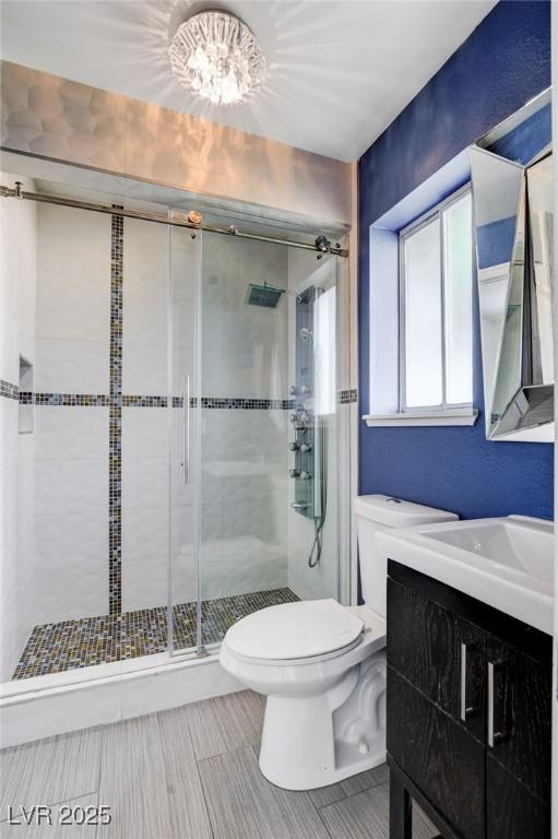 7575 Coley Ave, Las Vegas, NV 89117 - bathroom with vanity, a shower stall, a chandelier, and tile patterned floors