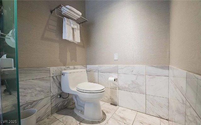 4381 W Flamingo Rd Unit 1212, Las Vegas, NV 89103 - bathroom featuring an enclosed shower, toilet, wainscoting, and tile walls