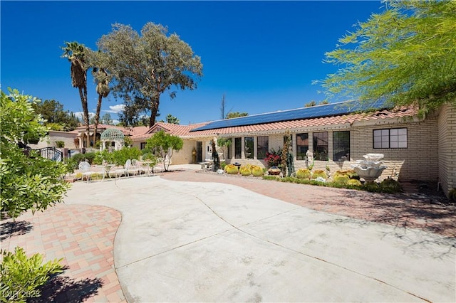 2255 S Buffalo Dr, Las Vegas, NV 89117 - back of property featuring a tiled roof, solar panels, and brick siding