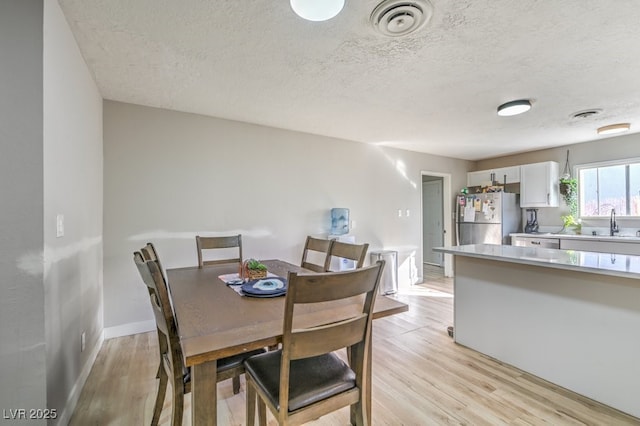2129 N Michael Way, Las Vegas, NV 89108 - dining room featuring light wood-type flooring and a textured ceiling