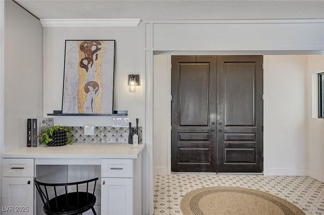 interior space with baseboards and backsplash