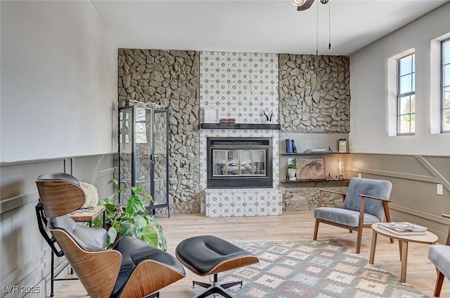 sitting room featuring wood finished floors and a glass covered fireplace