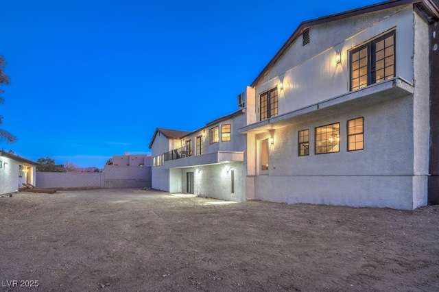 back of property with fence and stucco siding