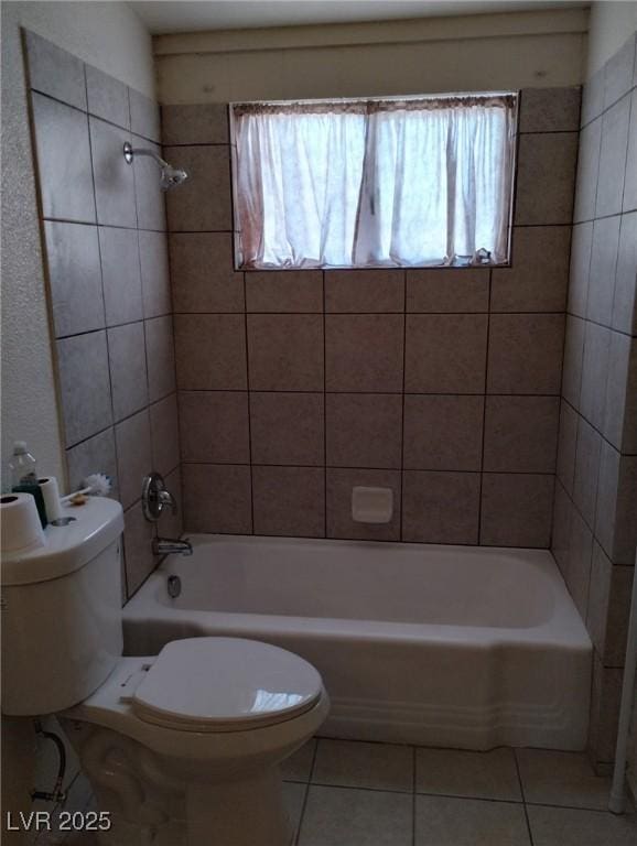 full bath featuring washtub / shower combination, toilet, and tile patterned flooring