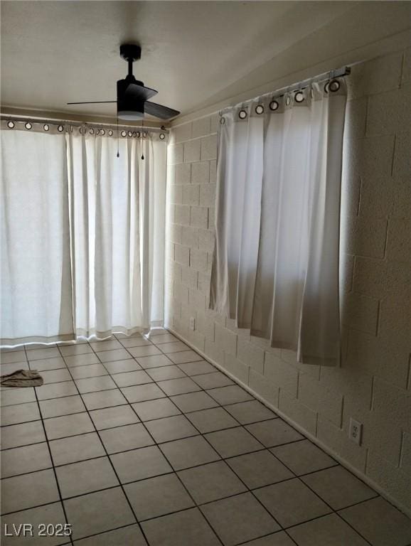 tiled spare room featuring ceiling fan