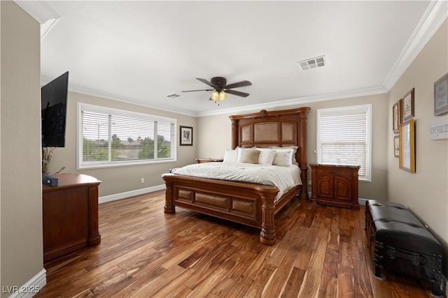 bedroom featuring crown molding, a ceiling fan, visible vents, baseboards, and wood finished floors