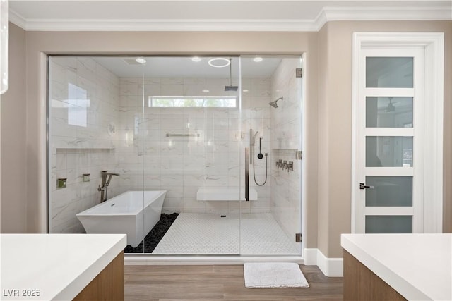 bathroom with wood finished floors, vanity, ornamental molding, and a stall shower