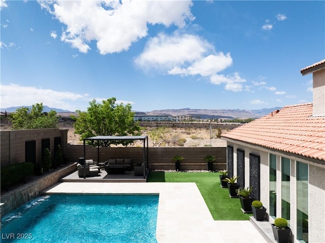 view of swimming pool with a mountain view, a fenced in pool, an outdoor hangout area, and a fenced backyard