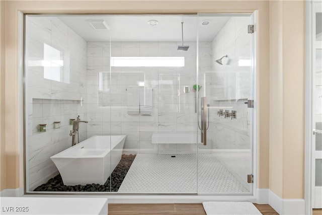 full bathroom featuring wood finished floors, a shower stall, and a soaking tub