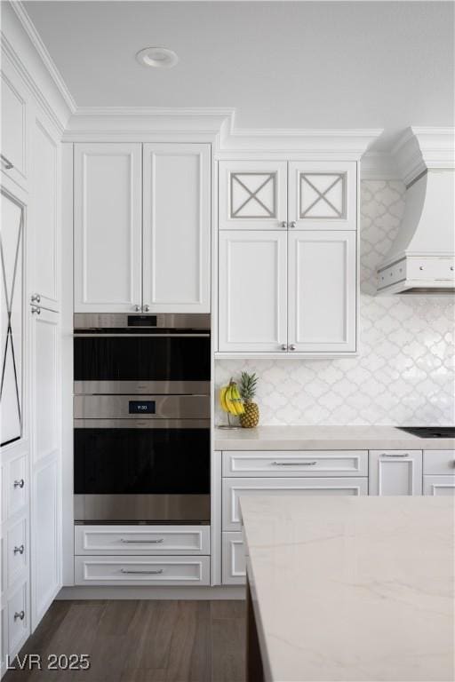 kitchen featuring white cabinetry, custom exhaust hood, ornamental molding, and backsplash